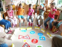 Kinder im Stuhlkreis Verkehrszeichen auf dem Boden